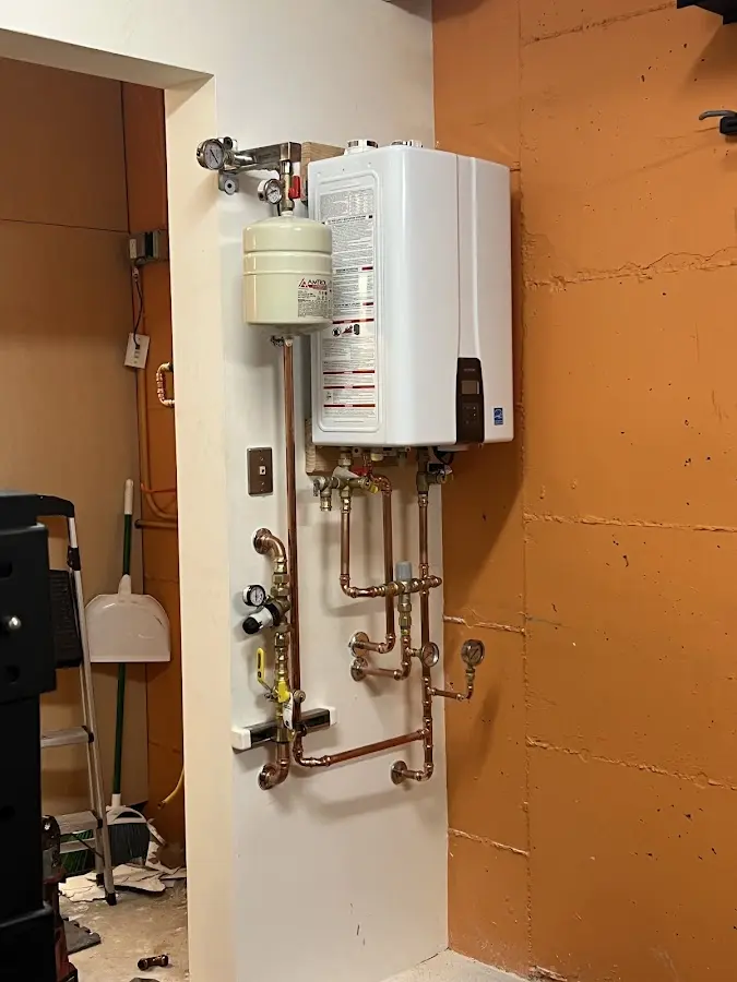 Plumbing technician inspecting water heater connections in Cave Creek